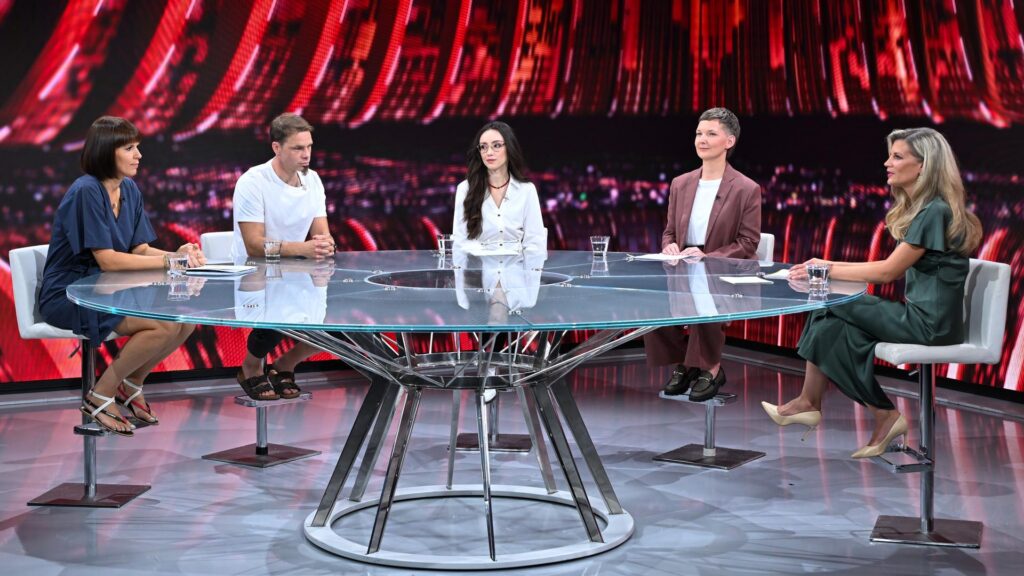 Fotografija sodelujočih v oddaji omizje, ki sedijo ob okrogli mizi v studiu: Petra Zupančič, Robert Železnik, Sara Bugarinović, Katja K. Ošljak in Tina Antončič.